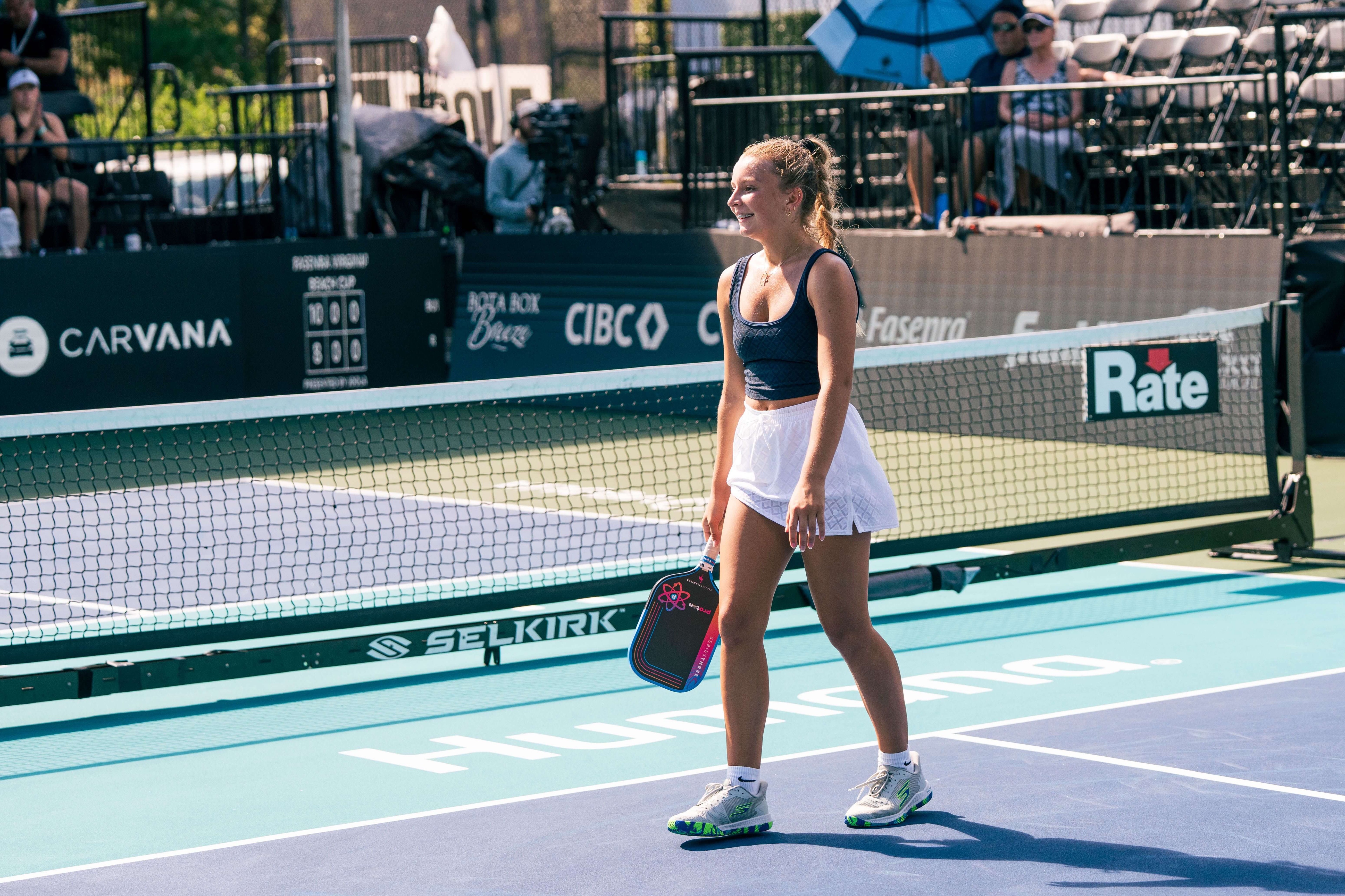 Rau in navy tank top and white skirt
